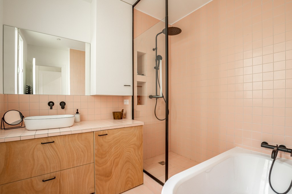 Salle de bains rénovée aux tons bois et rose – appartement CAIL, Paris 10e