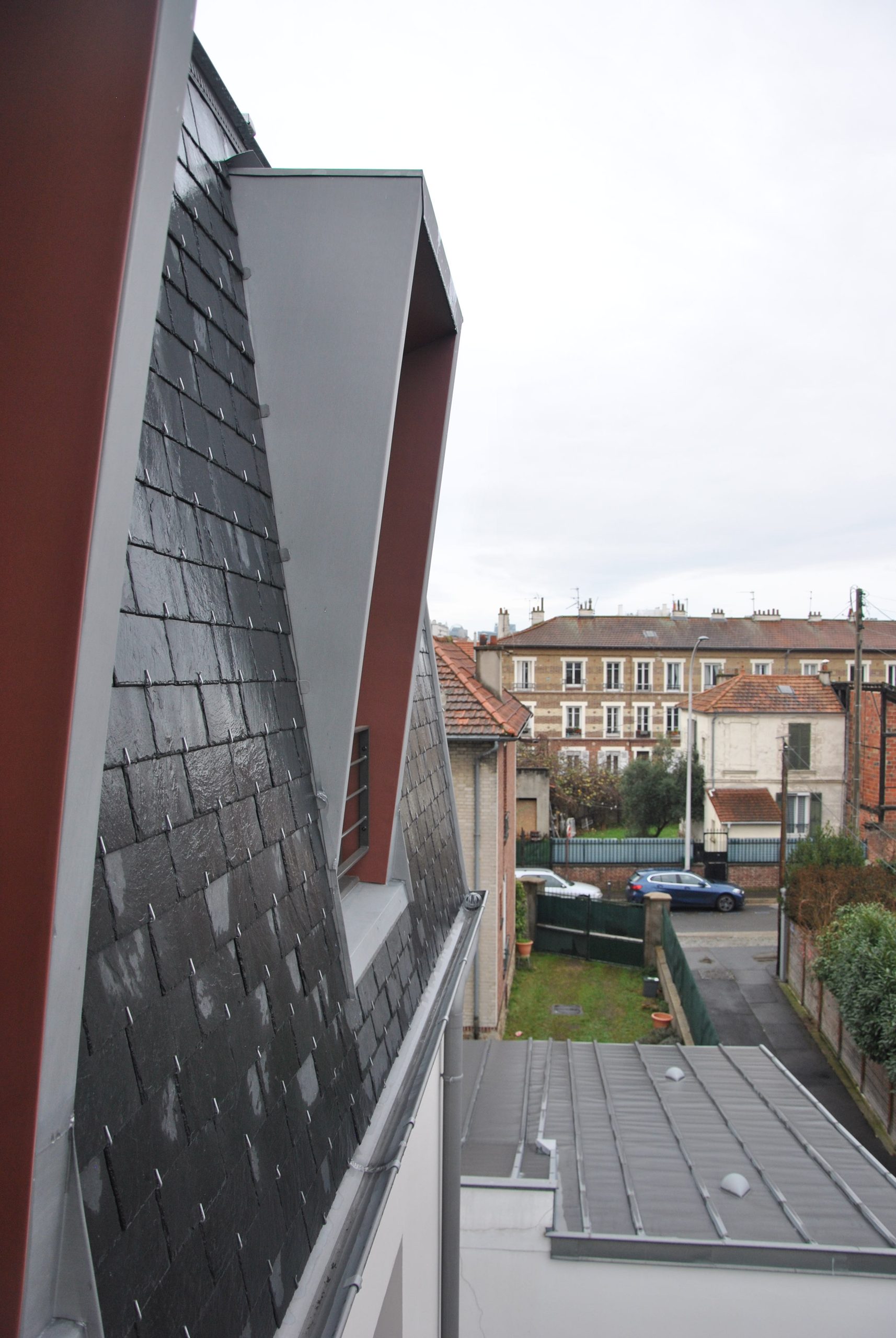 Surélévation avec façade en ardoise et encadrements de lucarnes en zinc colorés – Bois-Colombes