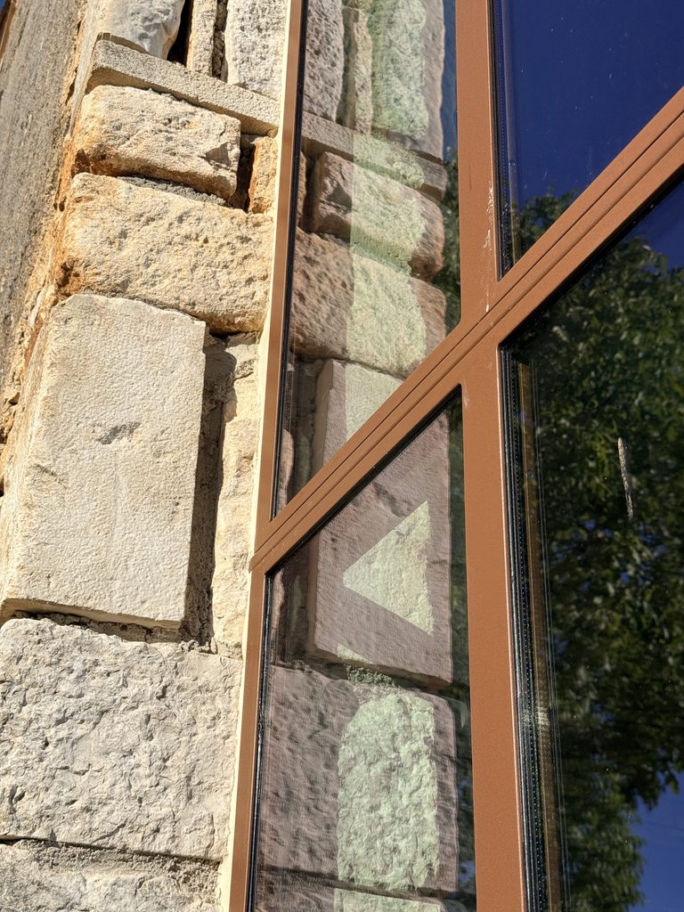 Détail de menuiserie dans la façade en pierre de la grange réhabilitée – Lot