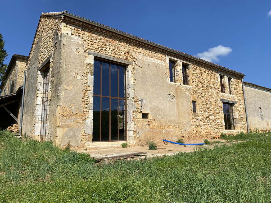 Façade de la grange réhabilitée avec grande baie vitrée – Lot