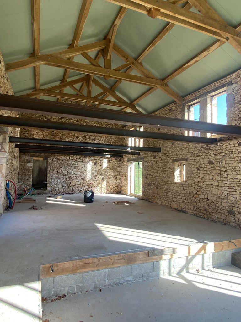 Volume intérieur de la grange avec charpente bois et poutres métalliques – Lot