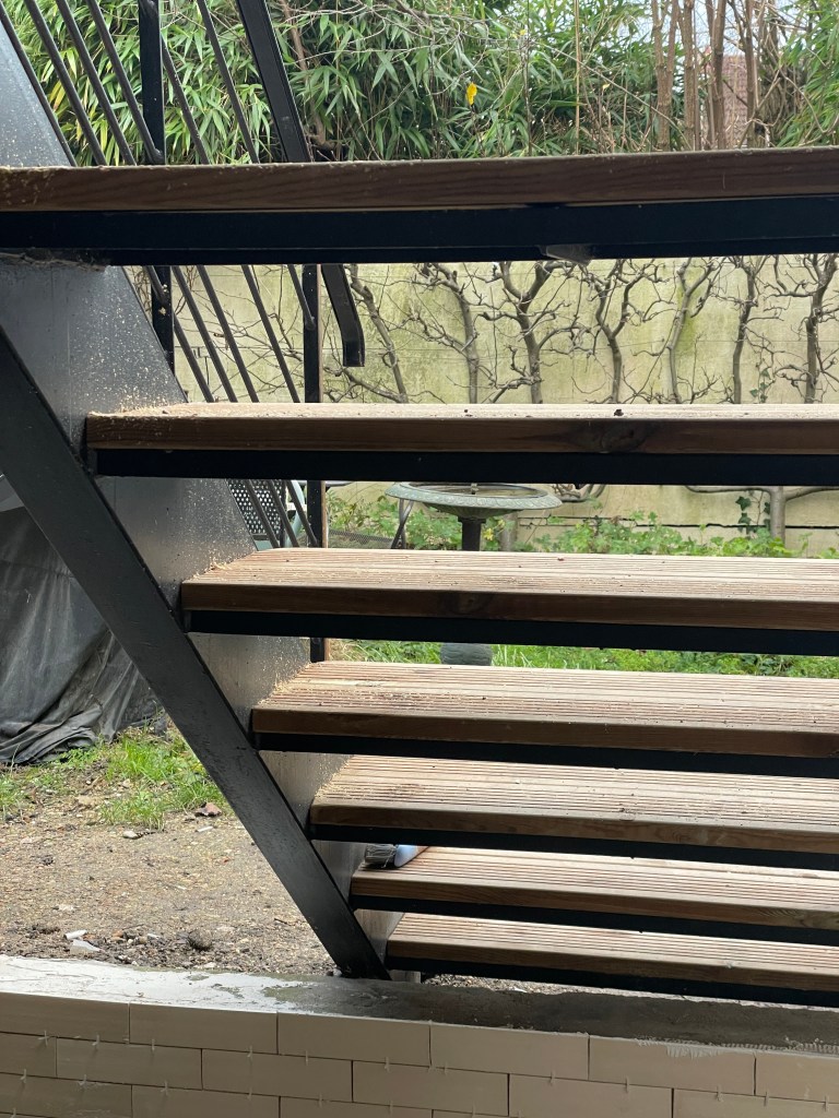 Escalier métallique avec marches en bois reliant la terrasse au jardin – Chaville